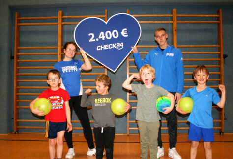 Trainer*in Mariia Merzliakova und Cassius Kamal mit Kindern der Ballschule